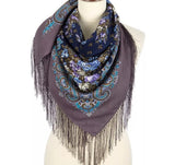 Decorative scarf with floral patterns and fringes on a mannequin against a white background