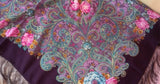 Close-up of a woolen women shawl with pink paisley and floral patterns in vibrant colors.