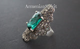 very large ring with faceted green stone, marcasite and made of silver on a black surface with Armenian Spirit title