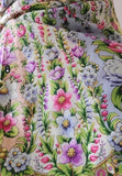 Close-up of a floral patterned shawl with pink, purple, and green colors.