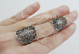 A sterling silver full finger ring with a double shield design, featuring intricate cut-out patterns, displayed on a person's hand.
