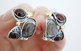 A pair of silver strange form earrings featuring natural garnet and labradorite gray gemstones, with gold plating on the metal.
