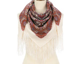 Paisley patterned white scarf with fringe and ethnic brick red pattern on a mannequin against a white background