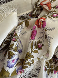 Floral patterned shawl with fringes on a neutral background