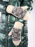 A close-up view of thick knitted winter handwarmers in pristine white with a traditional Scandinavian jacquard layout. The heavily brushed wool surface gives the product a super soft and fluffy appearance.