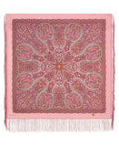 Pink woolen square scarf with intricate paisley pattern and white fringe on a pink background