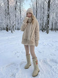 A blond woman wearing a pair of slavic valenki boots in a modern variation in a winter forest with snowy trees. Heavy-duty traditional Slavic felt boots featuring a seamless wool upper and a thick textured winter sole for walking safely on ice and wet slushy snow.