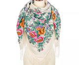 Floral patterned merino wool scarf with fringes on a mannequin against a white background