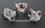 A pair of silver earrings and ring featuring natural garnet and labradorite gray gemstones, with gold plating on the metal.