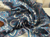 Close-up of patterned woolen shawl with blue, red, and white colors.