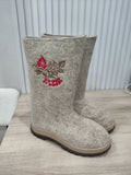 Fashionable unusual woolen boots for woman with wide and long shaft made of premium quality sheep wool and rubber outsole high platform on a wooden table.