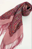 Pink merino wool scarf with ethnic paisley pattern and fringes on a white background