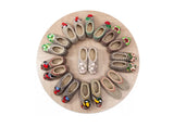 Round wooden board with a variety of woolen women chuni shoes on a white background