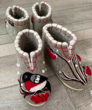 Pair of gray woolen chuni  slippers with bird and berry design on a wooden floor