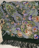 Floral patterned woolen green scarf with fringes on a green background