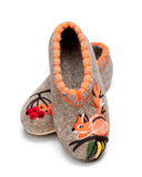 A pair of premium handmade wool felt slippers in a natural heather gray color, showcased on a white background. The left slipper features an artistic, handcrafted needle-felted design of a cute orange squirrel with a fluffy tail, black whiskers, and a green acorn. The right slipper is adorned with a traditional Slavic folk art embroidery design of a branch with green leaves and vibrant red and orange rowan berries.