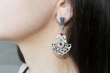 Aztec earrings always has semi-circle shape. These earrings are made in a shape of crescent and has ethnic ornament which remind ancient aztec patterns . The earrings looks very nice on the lobe and dangle till the middle of the neck. This store has various types of silver earrings in bohemian chic style. The stones are different, particulary the stone of these long semi circle earrings are small garnets red gemstones.