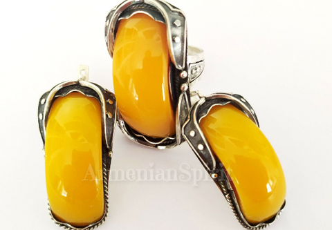 A real find for lovers of massive jewelry made of precious metals with natural stones! These earrings and ring are made in the Edwardian style with rough patterns and large oblong Baltic amber stones.