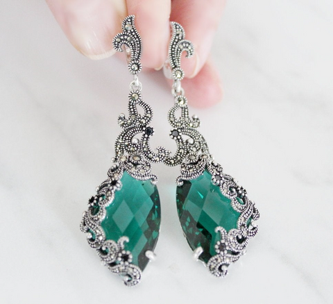 These glomorous long earrings is selling in our store as a best seller in earrings. The earrings are stylish and ancient looking with shiny marcasites, black onyx stiny stones and emerald green gemstone topaz. The lock is English lock with charming detail on it. The earrings are triangle with herbal pattern. 