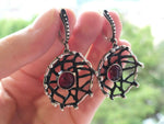 I want to buy a gift for my beloved wife, who loves unusual things. The jewelry set includes earrings and a ring resembling a net with a red garnet stone. The jewelry is made of precious metal, 925 sterling silver on the reverse side. Jewelry is made by Armenian craftsmen and has a unique and beautiful design without repetitions.