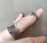 In our store you will find beautiful Bohemian style Armenian rings made of sterling silver 925. This ring consists of two rings connected by chains. It has several small red artificial garnet stones on it.