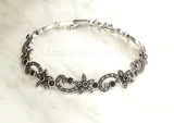 This Armenian Spirit bracelet features small flowers and a luxurious black onyx gemstone, all crafted with high-quality 925 sterling silver. The perfect gift for someone special, this bracelet exudes richness and elegance. Elevate any outfit with this exquisite piece of jewelry.