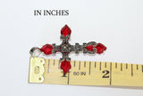 2 inch silver cross with marcasites near a yellow ruler showing 2 inch