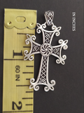 Armenian eight pointed silver cross with arevakhach eternity flower wheel in the center near a yellow ruler showing that it is bigger than one inch.