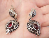 A pair of silver 925 sterling silver pomegranate earrings with red garnet red oval stones.