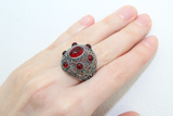 Dome ring on woman hand with multiple oval red stones and marcasite