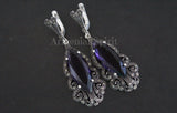 A pair of large sterling silver earrings, in a shape of peacock tail, with purple topaz and marcasite accents.