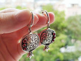 Buy pomegranate Armenian earrings with red garnet gemstones with traditional Armenian ornaments. The earrings are flat dangle and colored in silver black and red.