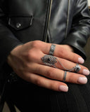 Set of Armenian traditional rings on women`s hand in black leather jacket