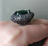 Buy massive dome ring with marcasites and emerald green round gemstone faceted. The ring  has a measurements approximately 5 cm diameter.